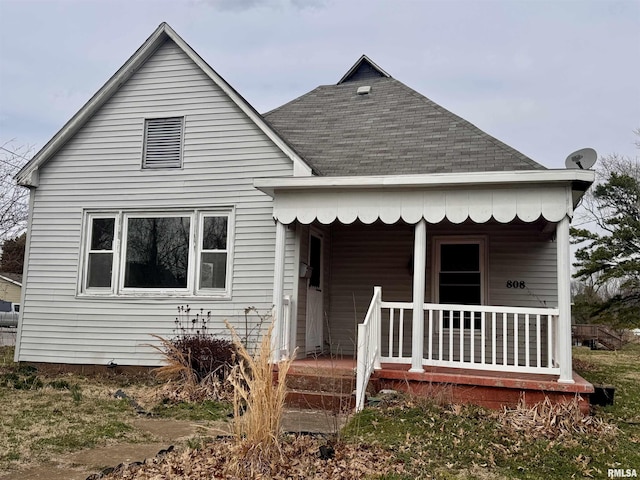 view of front of property featuring a shingled roof and covered porch