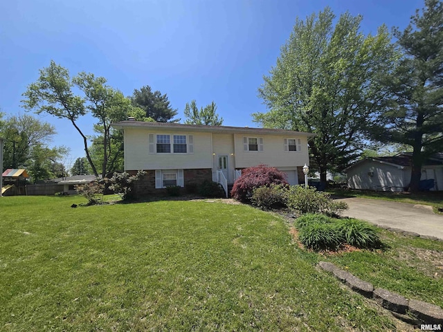 bi-level home featuring concrete driveway, a front yard, and a garage