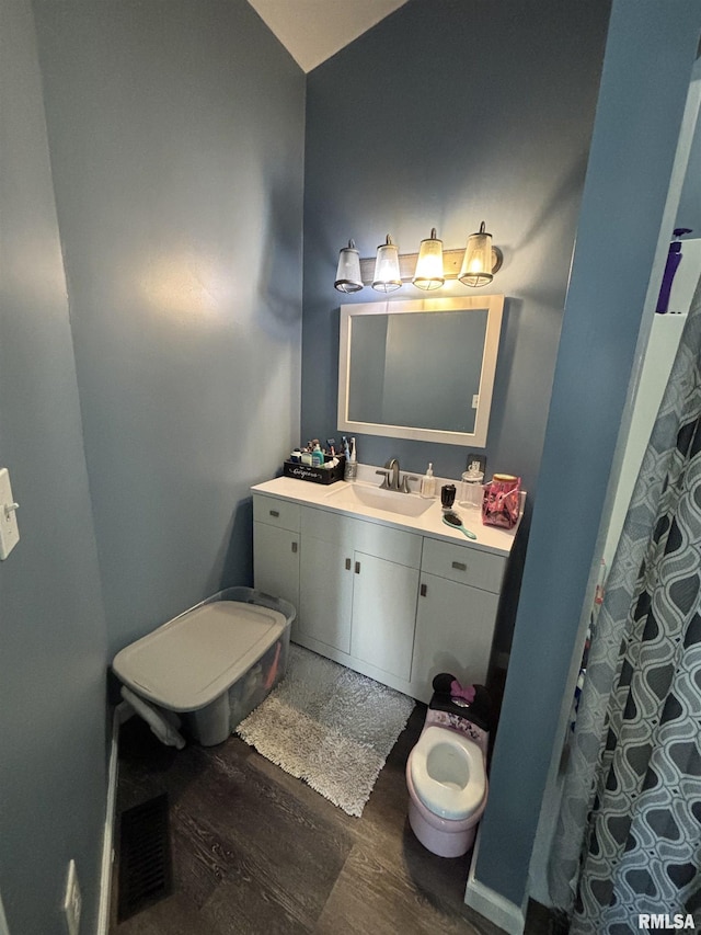full bath with vanity, visible vents, and wood finished floors