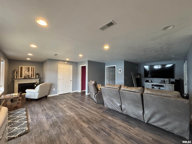 living area featuring visible vents, recessed lighting, wood finished floors, and a fireplace