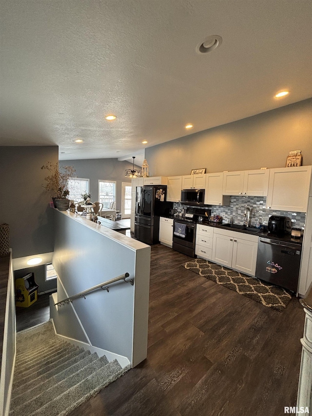 kitchen with white cabinets, dark wood-style floors, black appliances, and lofted ceiling
