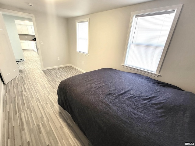 bedroom featuring baseboards and light wood finished floors