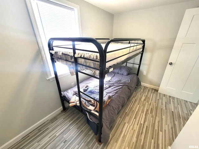 bedroom with wood finished floors and baseboards