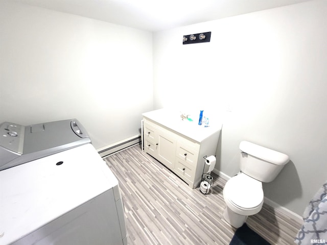 bathroom with washer / clothes dryer, vanity, baseboard heating, toilet, and wood finished floors