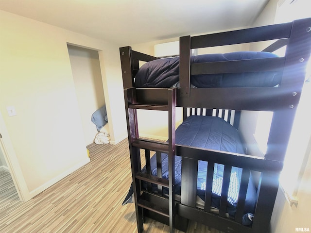 bedroom with baseboards and wood finished floors