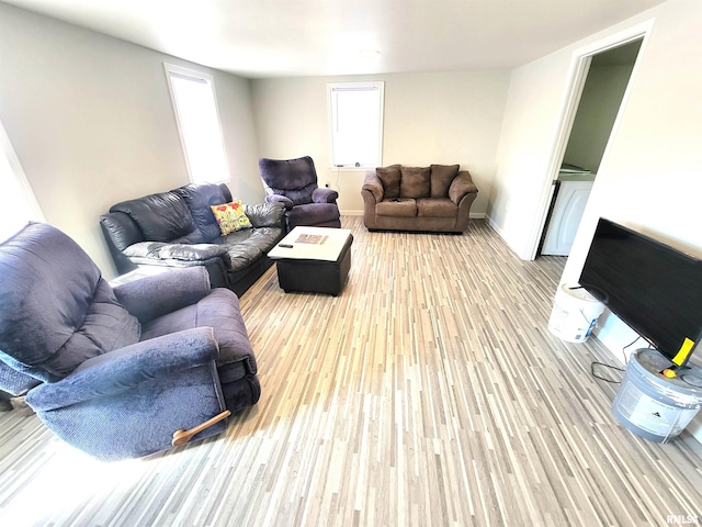 living area with baseboards and wood finished floors