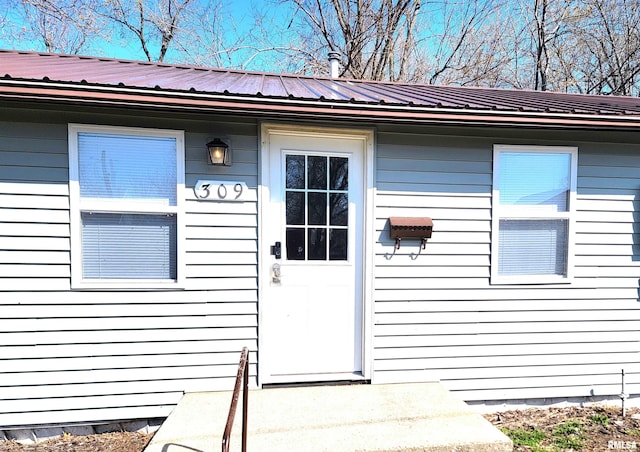 view of exterior entry featuring metal roof