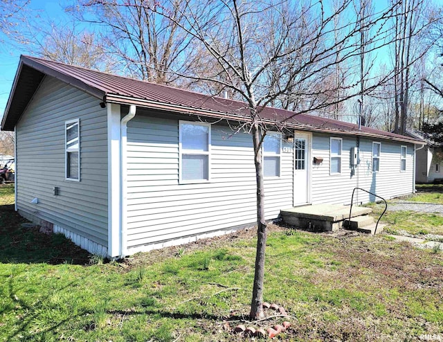 view of front of home featuring metal roof and a front yard