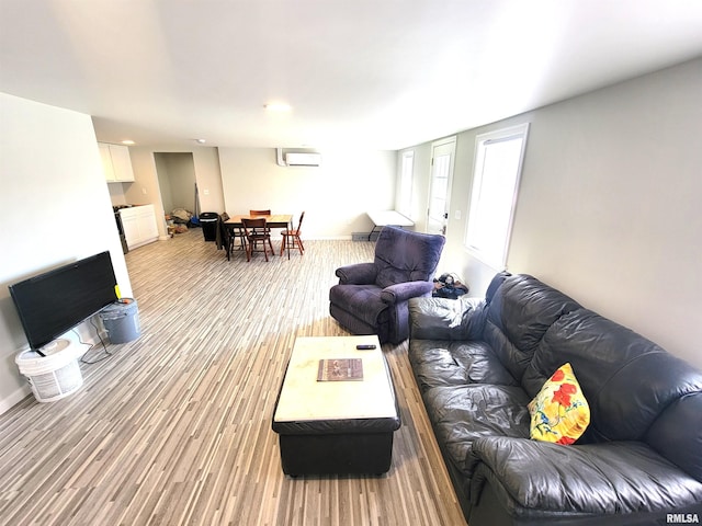 living area with light wood-style floors and a wall mounted AC