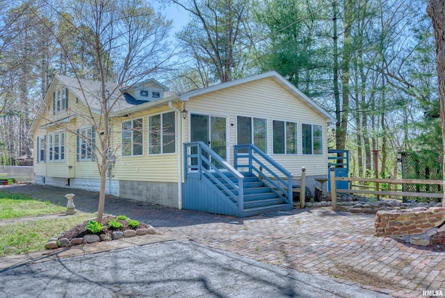 view of front facade featuring a sunroom and fence