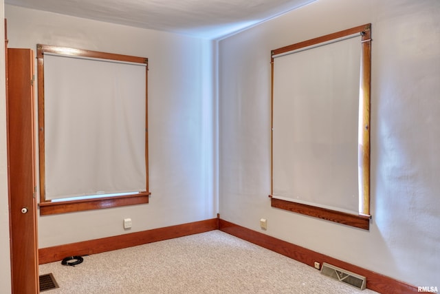 unfurnished room featuring carpet flooring, baseboards, and visible vents