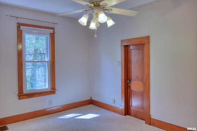 spare room featuring carpet flooring, baseboards, a ceiling fan, and visible vents