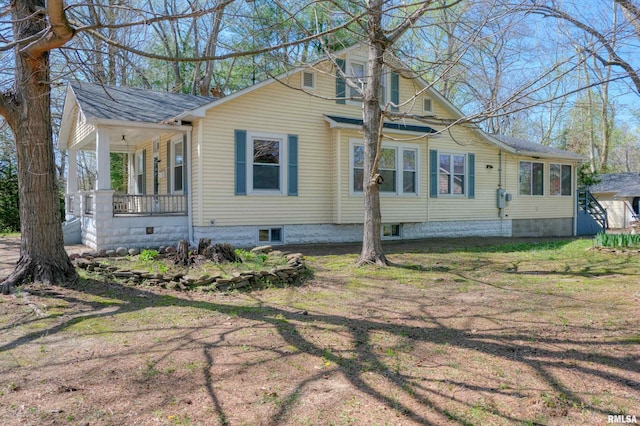 view of side of home with roof with shingles and covered porch