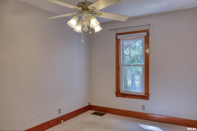 empty room with carpet flooring, visible vents, baseboards, and a ceiling fan