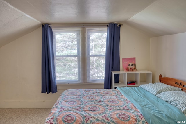 carpeted bedroom featuring multiple windows and lofted ceiling