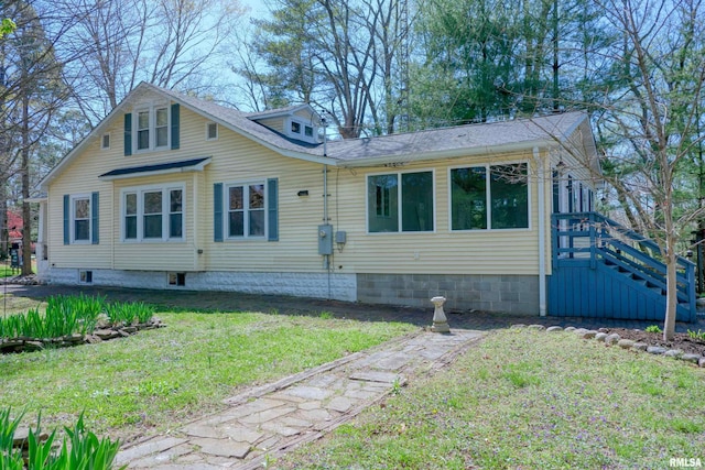 exterior space with a front yard and a shingled roof