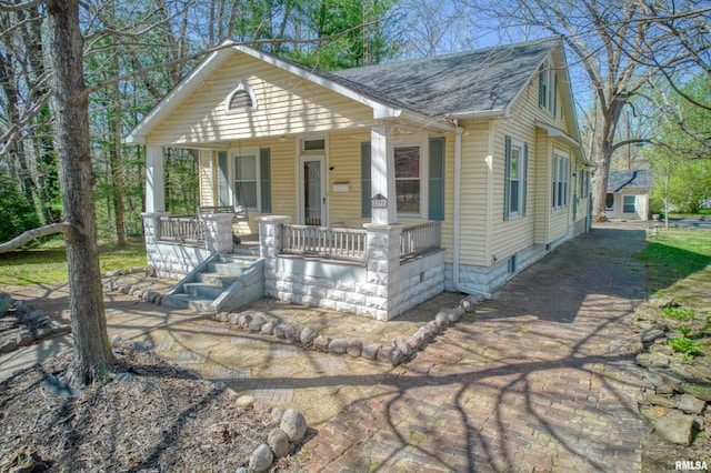 view of front of house featuring roof with shingles and covered porch