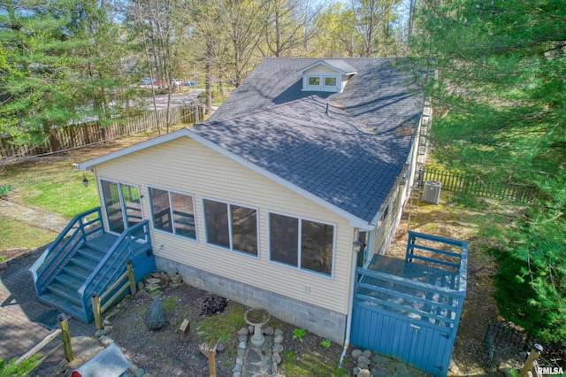 view of property exterior with fence and a shingled roof
