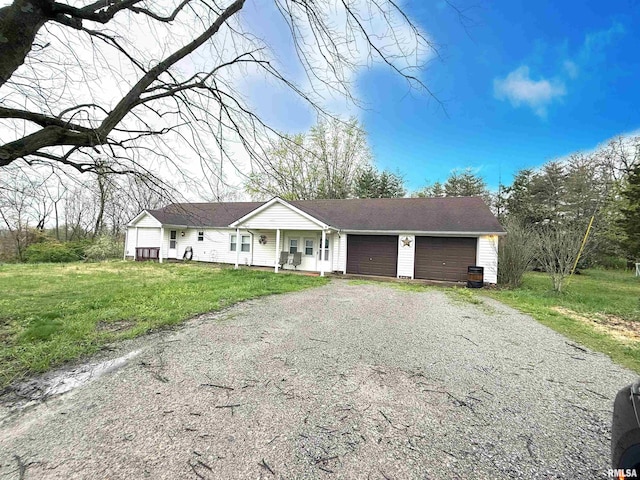 ranch-style house with a garage, gravel driveway, and a front lawn
