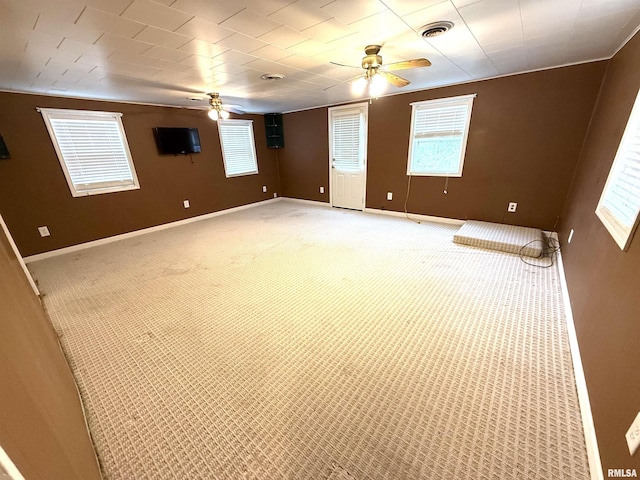 spare room with visible vents, ceiling fan, baseboards, and light carpet