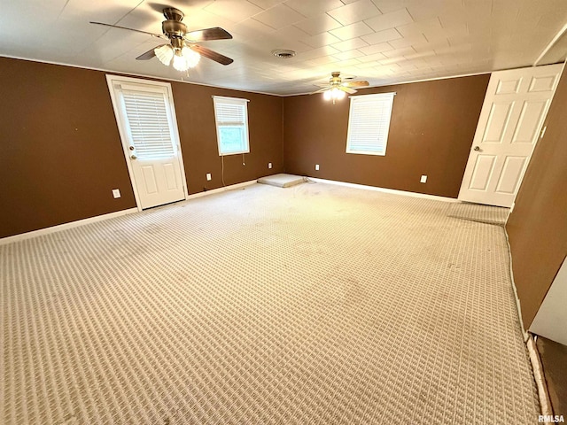 spare room featuring visible vents, baseboards, a ceiling fan, and light carpet