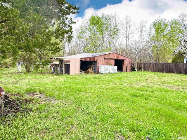 view of pole building featuring a yard and fence