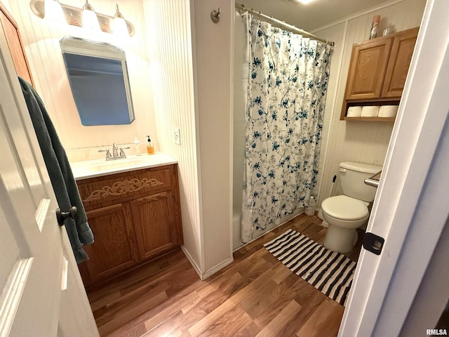 bathroom featuring toilet, vanity, and wood finished floors
