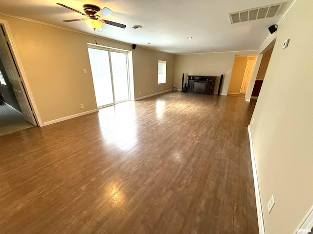 unfurnished living room with visible vents, ceiling fan, baseboards, and dark wood finished floors