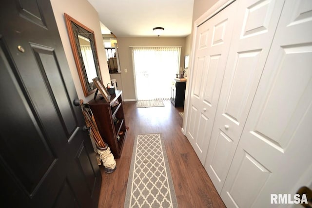 corridor featuring dark wood-style flooring and baseboards