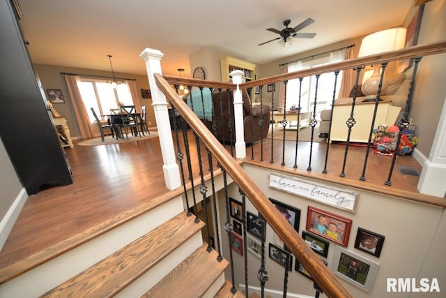 staircase featuring ceiling fan, wood finished floors, and baseboards