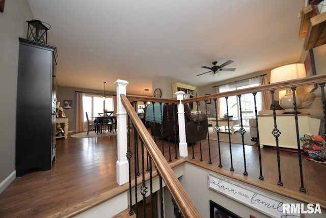 stairway with wood finished floors, baseboards, and a ceiling fan