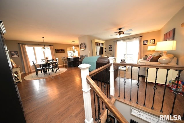 living area featuring wood finished floors, ceiling fan, and baseboards