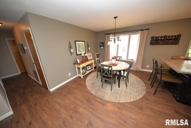 dining space featuring dark wood-style flooring, baseboards, and an inviting chandelier