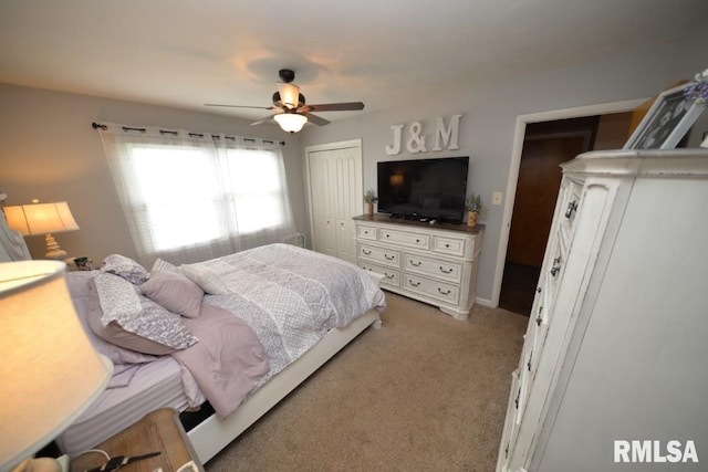 bedroom featuring light carpet, a closet, and a ceiling fan