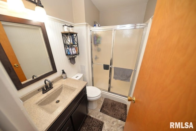 bathroom featuring a shower stall, vanity, and toilet