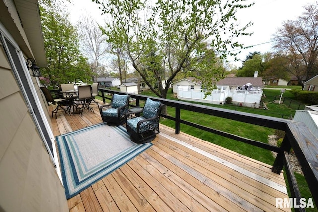 deck featuring outdoor dining space, a yard, a residential view, and an outbuilding
