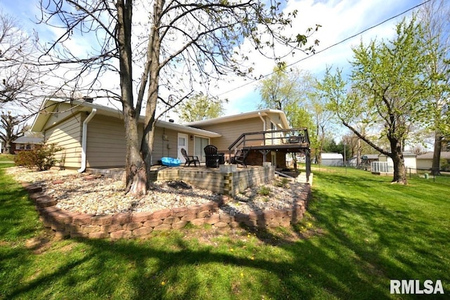 back of property with a patio, a yard, a wooden deck, and fence