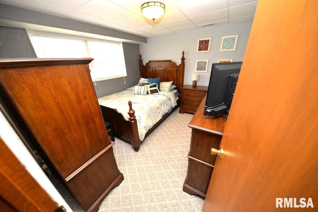 bedroom featuring visible vents, a paneled ceiling, and light carpet