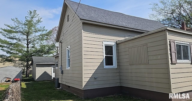 318 W Raymond St, Harrisburg, IL 62946 - view of side of property with roof with shingles, an outdoor structure, and a lawn