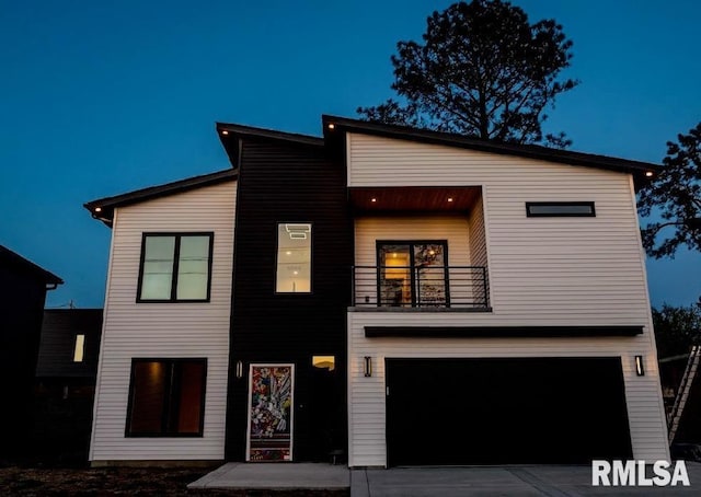 contemporary home featuring a garage, driveway, and a balcony