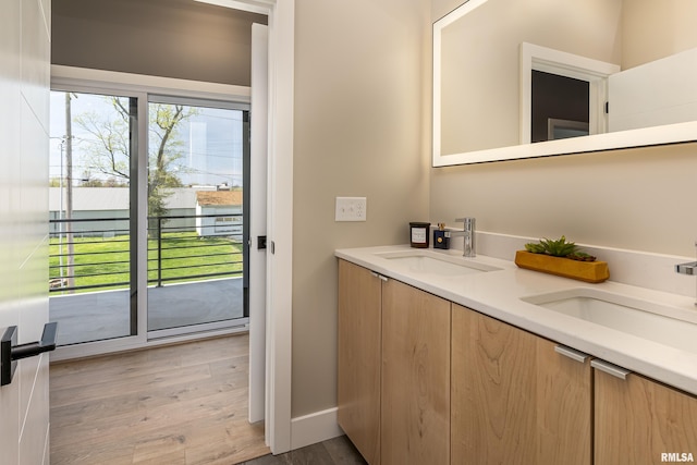 bathroom featuring double vanity, a sink, and wood finished floors