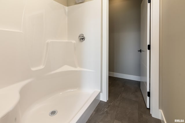 full bathroom with a shower and baseboards