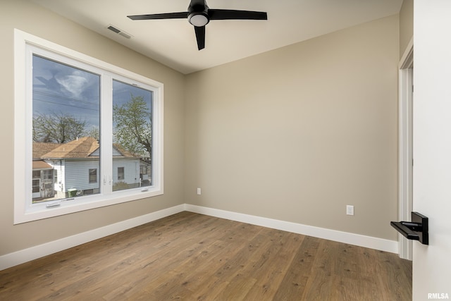 unfurnished room featuring baseboards, wood finished floors, and ceiling fan