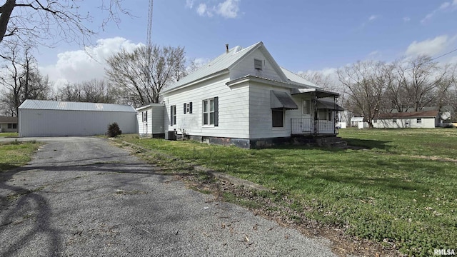 205 Shaw St, Harrisburg, IL 62946 - view of property exterior with aphalt driveway, central AC, a yard, an outdoor structure, and metal roof