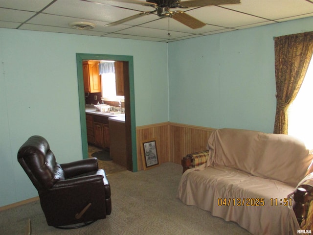 229 S James St, Centralia, IL 62801 - living area with ceiling fan, a paneled ceiling, carpet, wood walls, and a wainscoted wall
