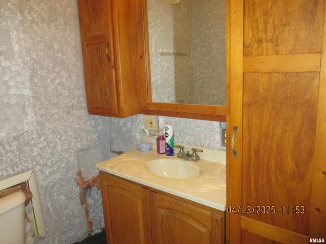 229 S James St, Centralia, IL 62801 - half bath featuring toilet, vanity, and wallpapered walls