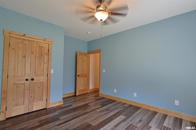 unfurnished bedroom featuring dark wood-style floors, baseboards, and ceiling fan