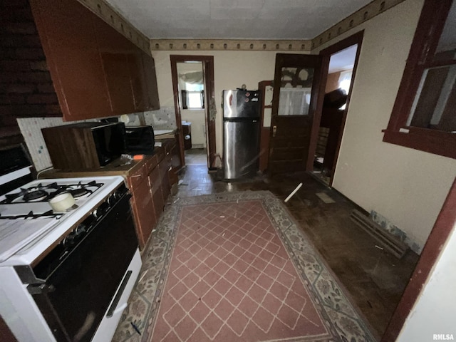 1012 W 9th St, Alton, IL 62002 - kitchen with black microwave, freestanding refrigerator, and gas stove