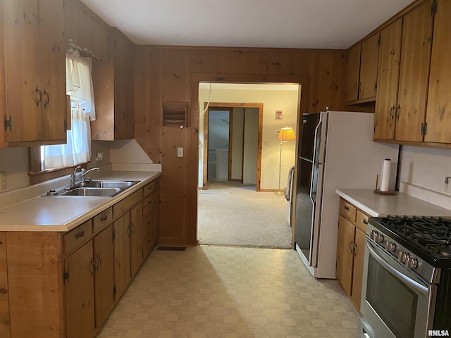 kitchen featuring a sink, light countertops, stainless steel gas range, and light floors