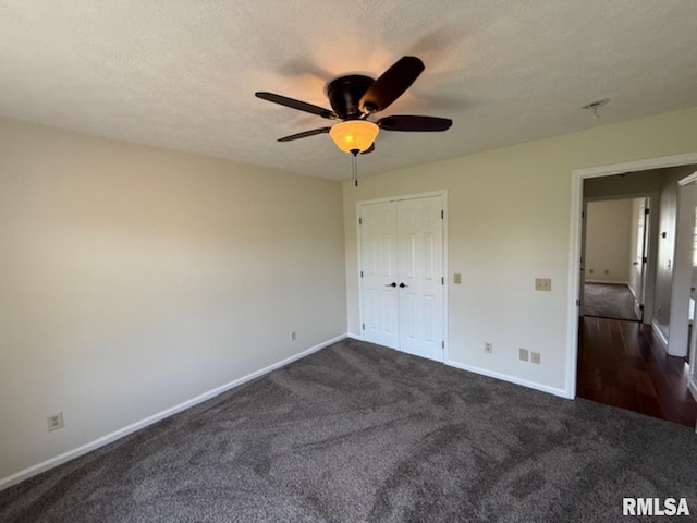unfurnished bedroom featuring dark carpet and baseboards